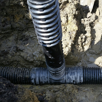 A closeup view of the Adjustable Inlet installed in a tee in an underground drainage system.